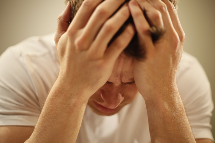 A man clutching his head.