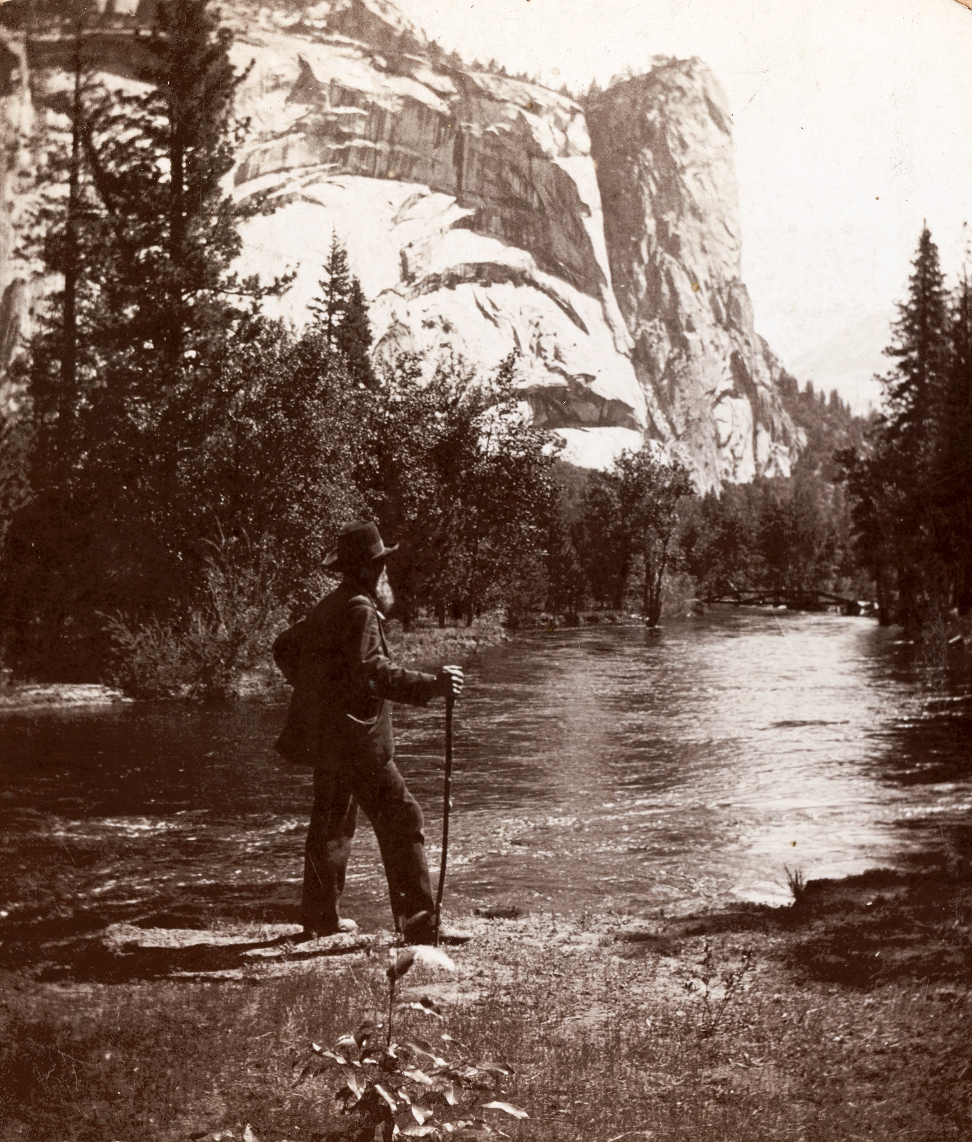 John Muir standing besides river at Yosemite valley.