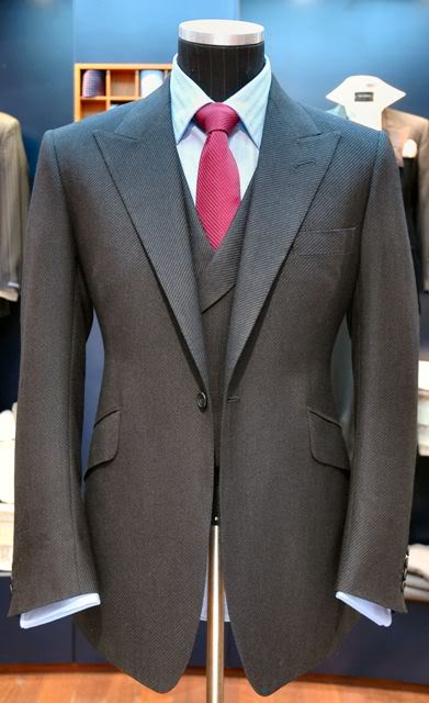 onebutton Gray suit hanging on dummy.