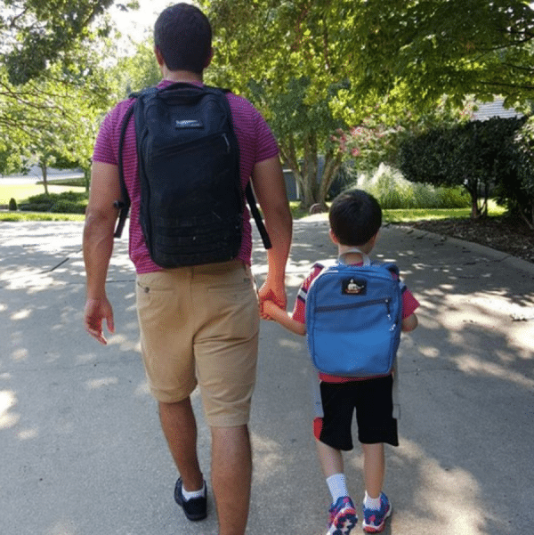 A man and kid going with there bags on back.